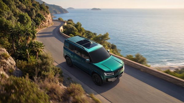 Teal BYD Ti7 SUV driving along a coastal cliff road