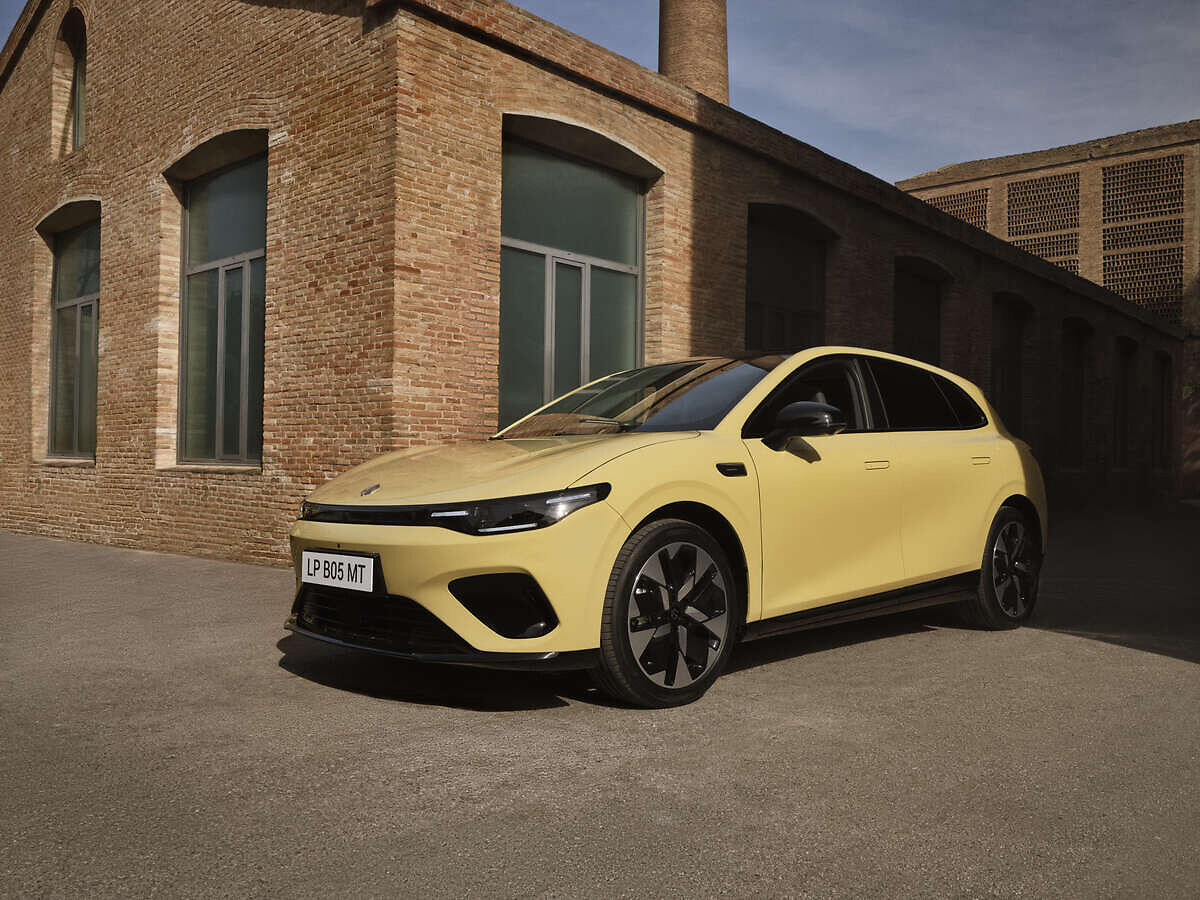 Yellow Leapmotor B05 parked outside a brick building with the driver's door open