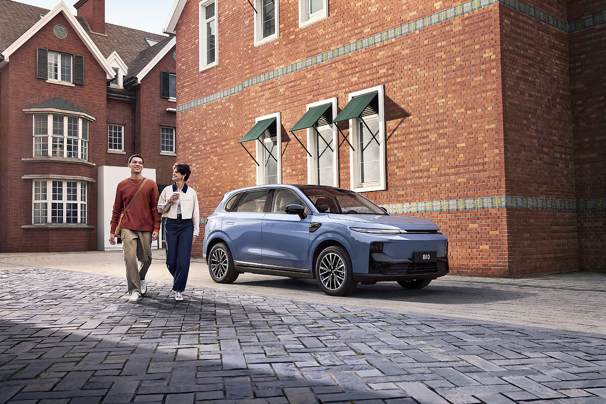 Light blue Leapmotor B10 parked in courtyard with couple walking past