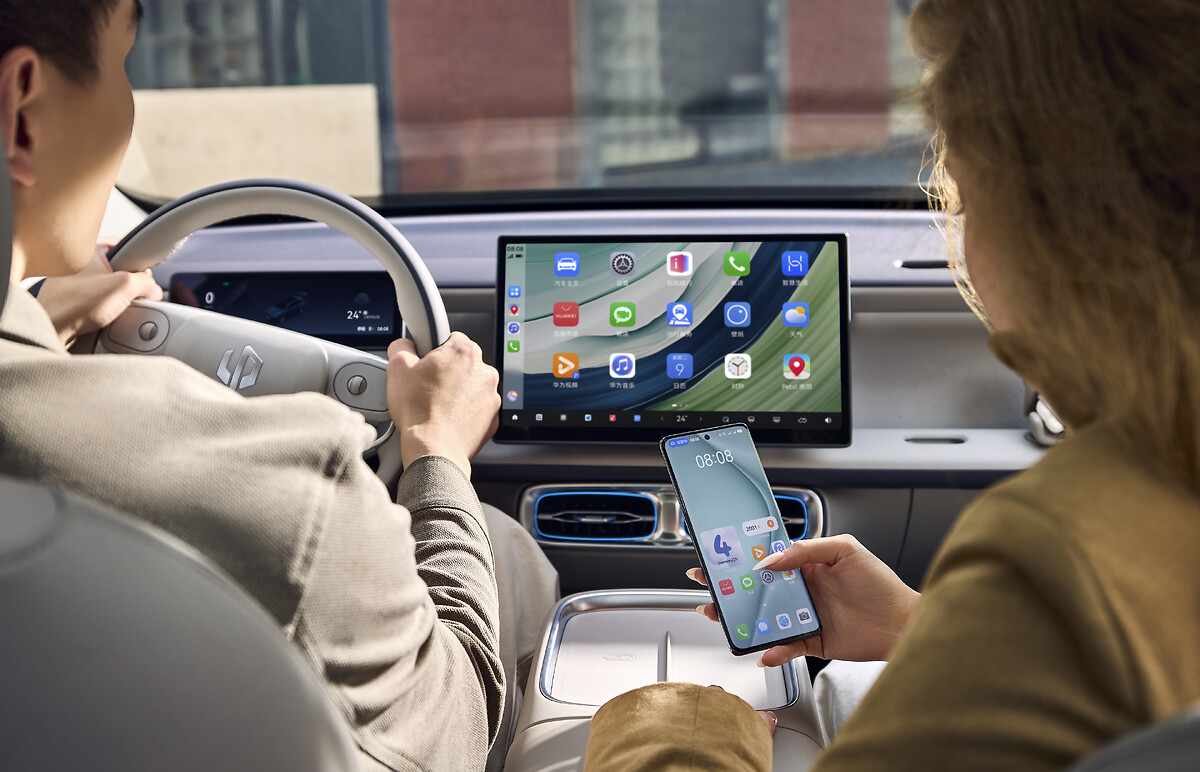 Driver and passenger using the 14.6-inch infotainment system with smartphone