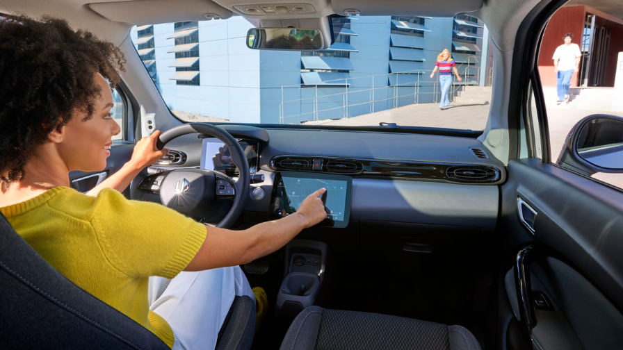 Woman driving the Leapmotor T03 with hands on steering wheel and touchscreen visible