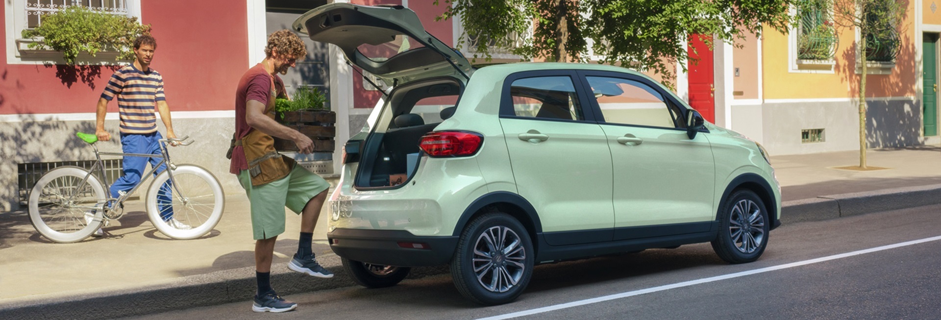 Light green Leapmotor T03 with open boot and people nearby on a street