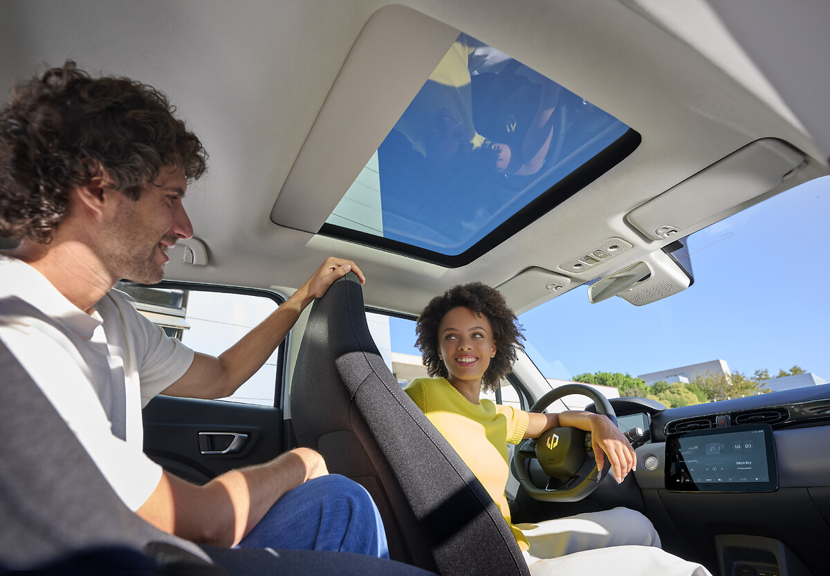 Two passengers enjoying the interior with panoramic sunroof open