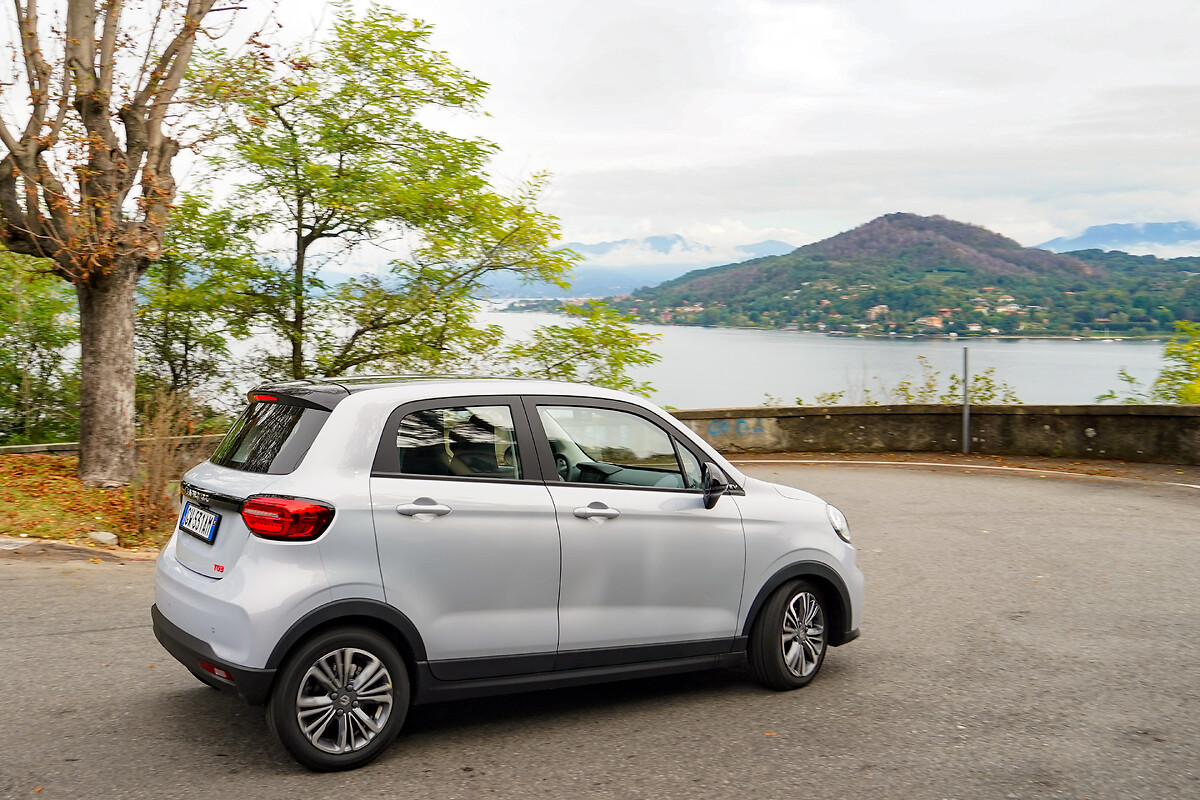 White Leapmotor T03 side profile with lake and mountains background showing 15-inch alloy wheels