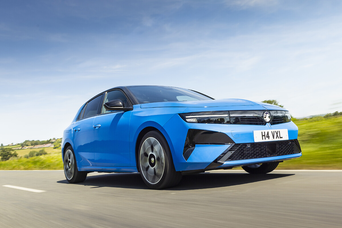 Blue Vauxhall Astra driving on road with green landscape